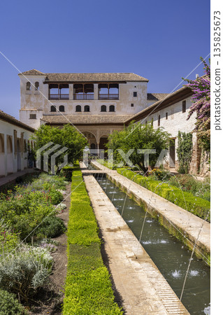 Generalife gardens featuring water fountains and historic Alhambra palace 135825673