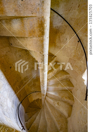 Stone spiral staircase leading upward in La Romieu, France Stone spiral staircase leading upward in La Romieu, France 135825703