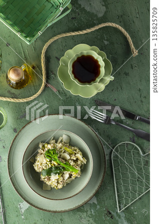 Risotto with broccoli and parmesan cheese served on green table Risotto with broccoli and parmesan cheese served on green table 135825709