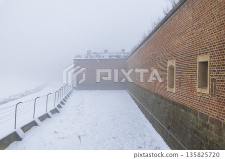 Mala Pevnost Terezin fortress wall in winter fog 135825720