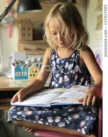 Child Reading a Book Intently at Home Child Reading a Book Intently at Home 135825985