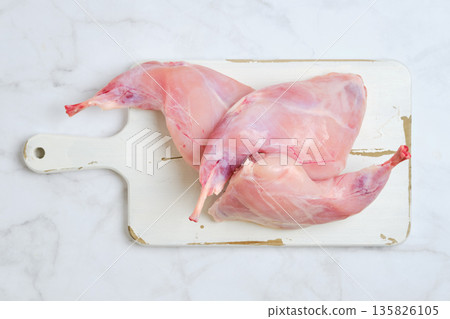 Hind leg of rabbit ready for cooking in stew on a cutting board in a kitchen setting Hind leg of rabbit ready for cooking in stew on a cutting board in a kitchen setting 135826105