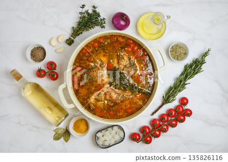 Slow cooking rabbit stew with fresh herbs and vegetables on a marble surface Slow cooking rabbit stew with fresh herbs and vegetables on a marble surface 135826116