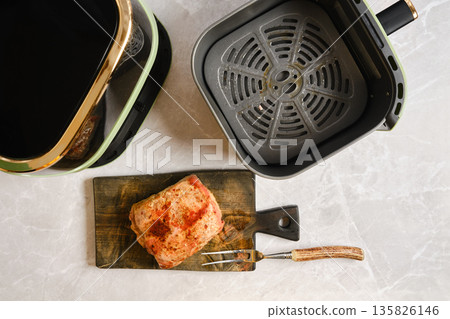 Pork tenderloin cooked in an air fryer on a wooden board in a kitchen Pork tenderloin cooked in an air fryer on a wooden board in a kitchen 135826146
