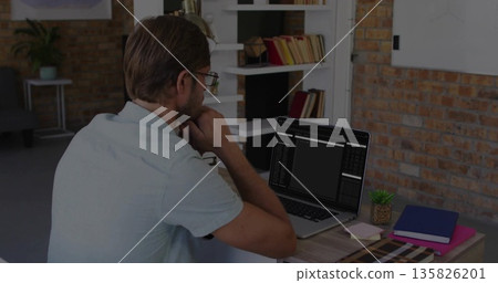 Resting head on hand, polo-clad developer focusing on laptop at office with succulent copy space 135826201