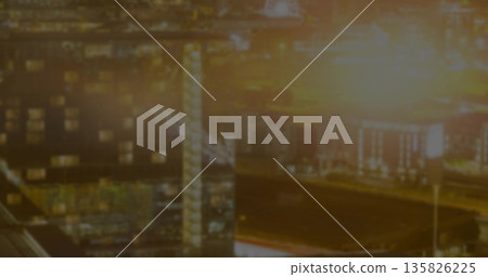 Glowing port warehouses with lattice tower casting light at night, with floodlights, loading docks Glowing port warehouses with lattice tower casting light at night, with floodlights, loading docks 135826225