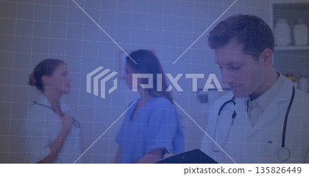 Doctor writing on clipboard in exam room, with lab coat, stethoscope and shelving unit, copy space 135826449