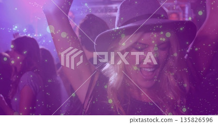 Cheering woman wearing wide-brim hat at club under metal trusses stage lighting fixtures bokeh 135826596