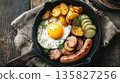 Delicious skillet breakfast with fried egg, sausage, and potatoes 135827256