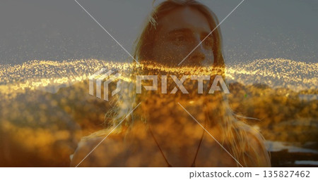 Shirtless man wearing pendant necklace gazing over city at rooftop terrace, with glowing light 135827462