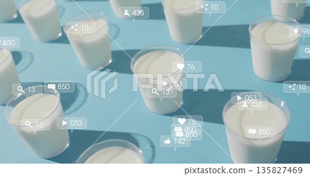 Social media icons hovering above clear plastic cups with white yogurt on blue table, with counters Social media icons hovering above clear plastic cups with white yogurt on blue table, with counters 135827469