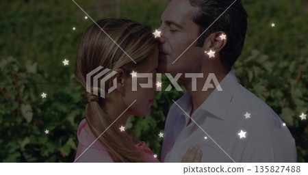 Sharing forehead kiss man gently pressing lips on woman in lush vineyard rows with star lights 135827488