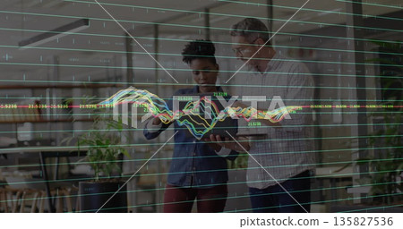 Examining tablet man and woman analyzing data inside open-plan office, with translucent line charts Examining tablet man and woman analyzing data inside open-plan office, with translucent line charts 135827536