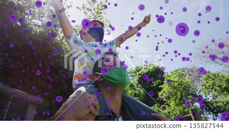 Man carrying boy on shoulders at park, face masks, purple virus overlay, playground beams, chains Man carrying boy on shoulders at park, face masks, purple virus overlay, playground beams, chains 135827544