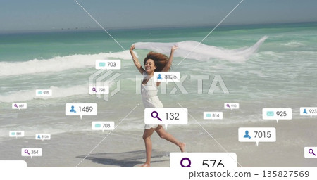 Running woman in white sundress holding scarf on sandy beach, with search message follower icons 135827569