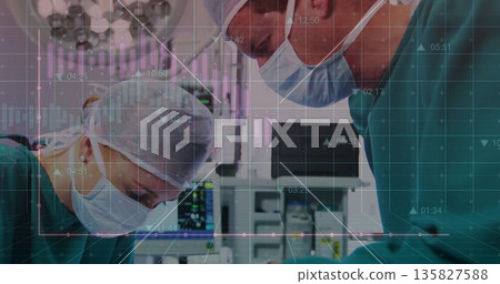 Surgeons operating under overhead lights in OR, with vital-sign monitors and data overlay 135827588