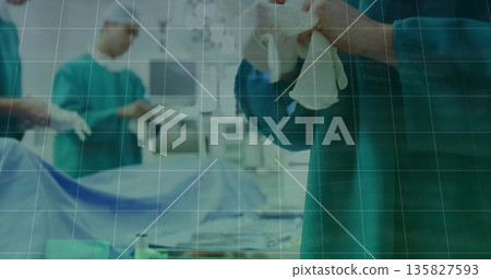 Preparing surgeon hands with surgical gloves in operating room, with instrument tray, copy space 135827593