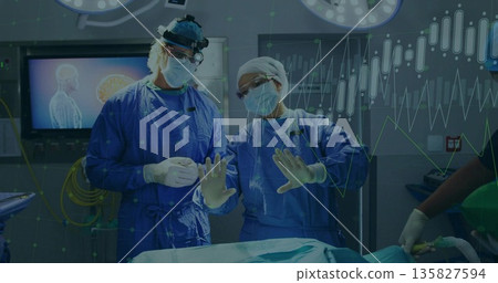 Performing surgical team manipulating instruments in hospital operating theater, with brain scan 135827594