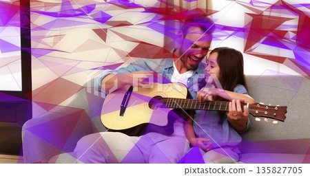 Playing father guiding daughter's hand on acoustic guitar on gray sofa at home, beige curtains Playing father guiding daughter's hand on acoustic guitar on gray sofa at home, beige curtains 135827705