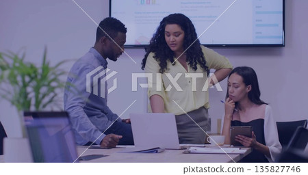 Reviewing team pointing at laptop in conference room with colleague holding tablet and pen Reviewing team pointing at laptop in conference room with colleague holding tablet and pen 135827746