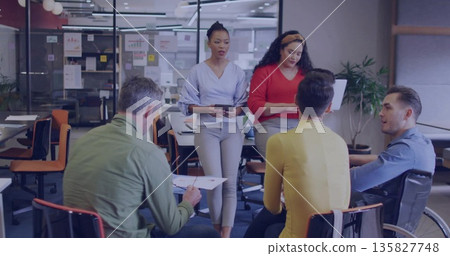 Discussing team collaborating around table in conference room, with wheelchair, tablet, documents Discussing team collaborating around table in conference room, with wheelchair, tablet, documents 135827748