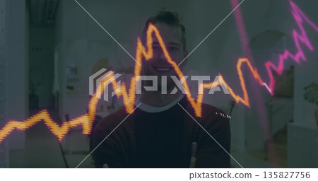 Smiling man in sweater standing in office, with laptop, plant and colorful financial chart overlay Smiling man in sweater standing in office, with laptop, plant and colorful financial chart overlay 135827756