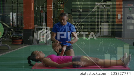 Coaching male instructor guiding female client on pink mat at gym, with barbells and cable machines Coaching male instructor guiding female client on pink mat at gym, with barbells and cable machines 135827774
