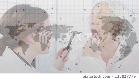 Examining doctor holding otoscope near seated patient tongue in exam room, digital overlay Examining doctor holding otoscope near seated patient tongue in exam room, digital overlay 135827779