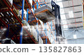 Raising forklift mast and forks lifting wrapped pallet inside warehouse, racks and digital overlay 135827863