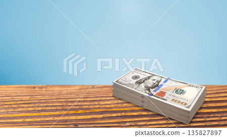 A thick stack of 100 US dollar bills sitting on a rustic wooden surface against a clean light blue background. Ideal for financial, banking, and wealth-related concepts with plenty of copy space A thick stack of 100 US dollar bills sitting on a rustic wooden surface against a clean light blue background. Ideal for financial, banking, and wealth-related concepts with plenty of copy space 135827897