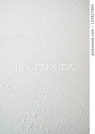 A close-up view of a gray painted surface featuring vertical liquid streaks and drips, creating a grunge industrial background for design projects 135827904