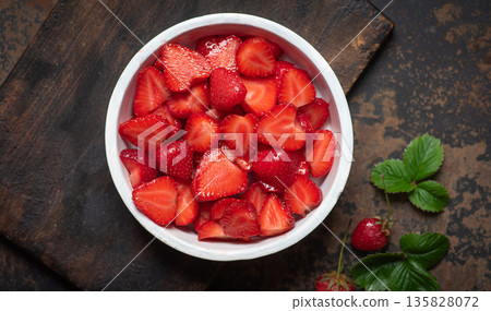 Freshly Sliced Strawberries In A White Bowl On A Rustic Background 135828072