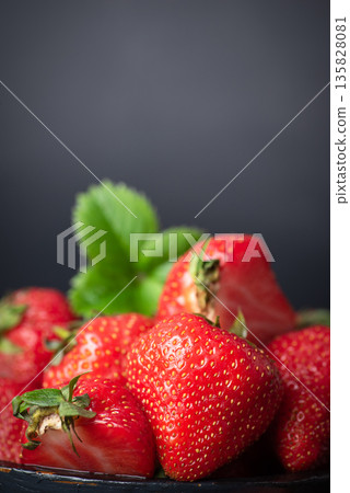 Vibrant Fresh Strawberries In Bowl On Dark Background 135828081