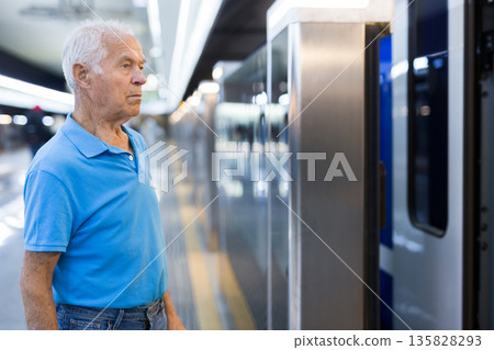 Old man standing in front of subway car 135828293
