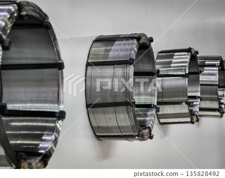 Coils of metal wire arranged on wall in workshop for manufacturing purposes Coils of metal wire arranged on wall in workshop for manufacturing purposes 135828492