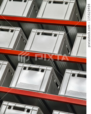 Storage containers arranged neatly on shelves in a warehouse setting for efficient organization and retrieval of items 135828494