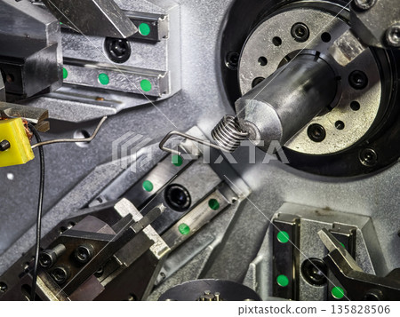 Machinery working on metal components in a factory setup during daylight hours Machinery working on metal components in a factory setup during daylight hours 135828506