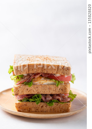 Whole wheat bread sandwich with bacon, lettuce, tomato and fried egg 135828820