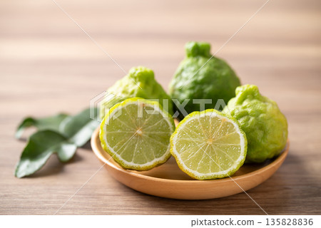 Kaffir lime fruit with leaf on wooden background, Thai food ingredient 135828836