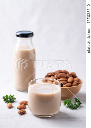 Almond milk and almond nuts on white fabric background, Alternative milk made from plant, Dairy free Almond milk and almond nuts on white fabric background, Alternative milk made from plant, Dairy free 135828840