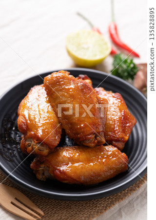 Grilled New Orleans chicken wings on a black plate with a fork Grilled New Orleans chicken wings on a black plate with a fork 135828895