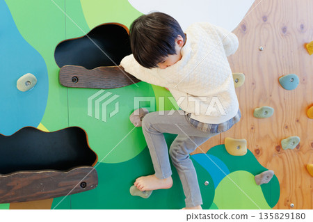 Boy playing bouldering 135829180