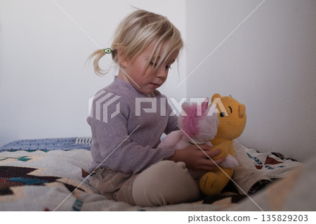 Cute little 4 year old girl playing with plush toys on the playground. Cute little 4 year old girl playing with plush toys on the playground. 135829203