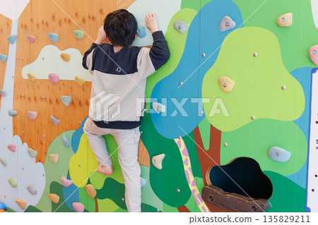 Boy playing bouldering 135829211