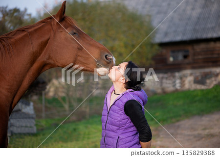 Gentle Moment Between Woman And Horse Outdoors Gentle Moment Between Woman And Horse Outdoors 135829388