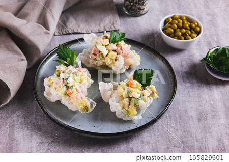 Olivier salad in rice paper bowls on a plate on the table Olivier salad in rice paper bowls on a plate on the table 135829601