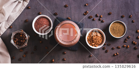 Coffee with spices and cocoa powder in a glass on the table top view web banner 135829616