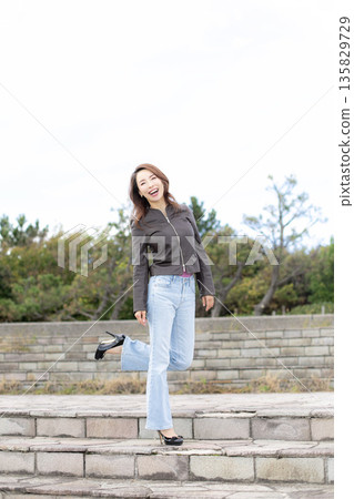 Beautiful woman walking in a city park 135829729