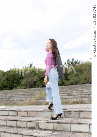 Beautiful woman walking in a city park Beautiful woman walking in a city park 135829743