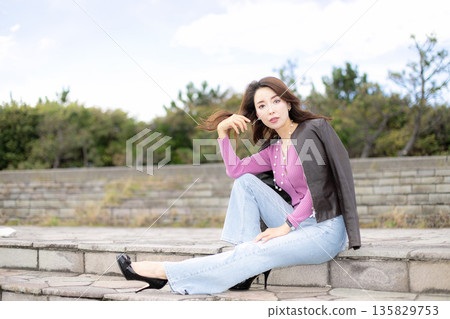 Beautiful woman walking in a city park 135829753